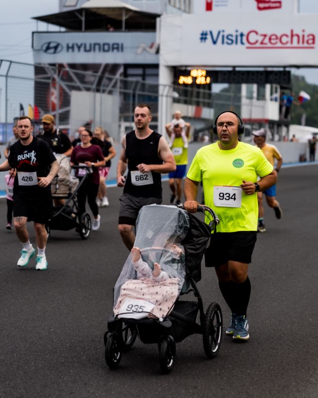 Runner pushing a stroller past the pit building